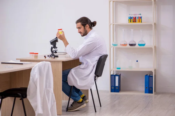 Junger Chemiker sitzt im Klassenzimmer am Schreibtisch — Stockfoto