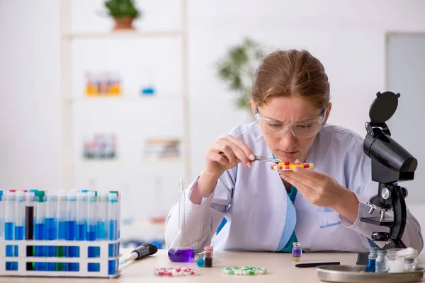Joven química femenina en concepto de síntesis de fármacos —  Fotos de Stock