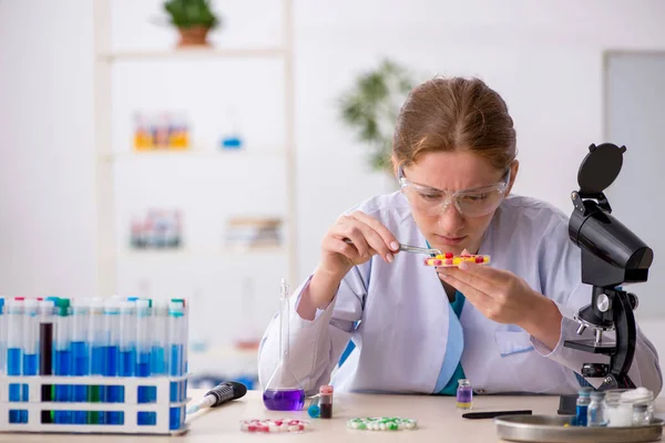 Jeune chimiste féminine dans le concept de synthèse de médicaments — Photo