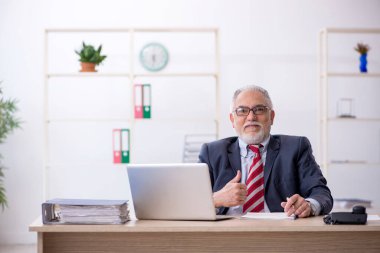 Ofiste çalışan yaşlı bir erkek.