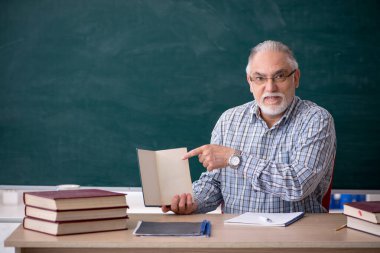 Sınıftaki yaşlı erkek öğretmen.
