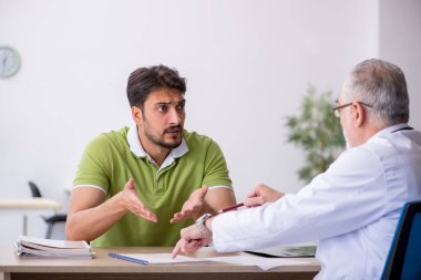 Genç adam ziyaret eski erkek doktor