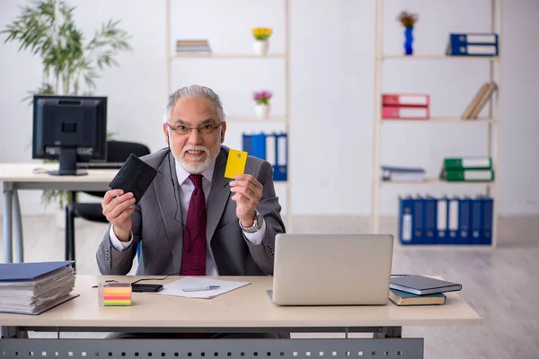 Stary pracownik posiadający kartę kredytową w biurze — Zdjęcie stockowe