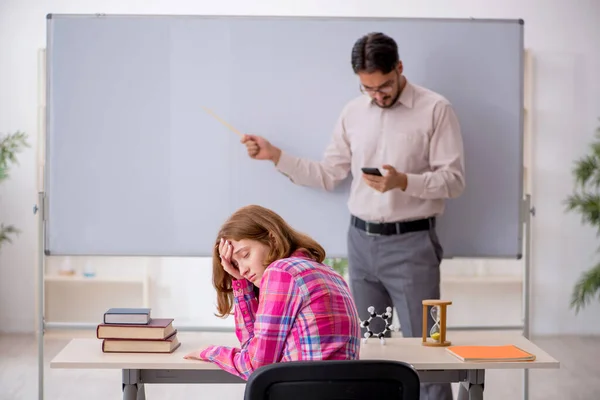 Ung manlig lärare och rödhårig flicka i klassrummet — Stockfoto