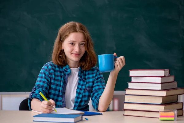 Unga kvinnliga studerande dricker kaffe under pausen — Stockfoto