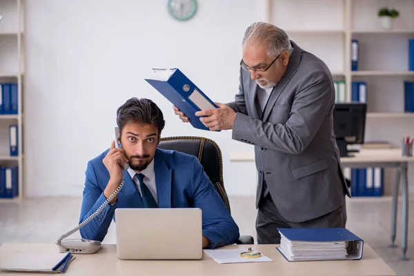 Viejo jefe y joven empleado masculino que trabaja en la oficina — Foto de Stock