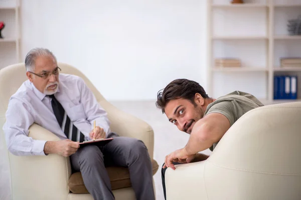 Jongeman op bezoek bij oude psycholoog — Stockfoto