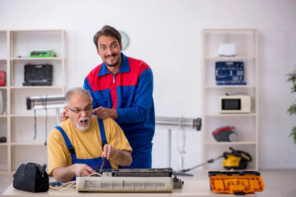 Dois reparadores do sexo masculino reparando ar ar condicionado — Fotografia de Stock