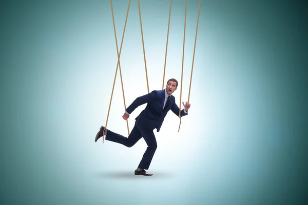 Geschäftsmannpuppe wird mit Seilen manipuliert — Stockfoto