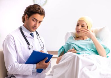 Genç, yakışıklı doktor kadın onkoloji hastasını ziyaret ediyor.