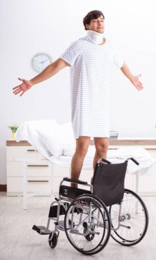 Hastanedeki tekerlekli sandalyedeki genç adam.
