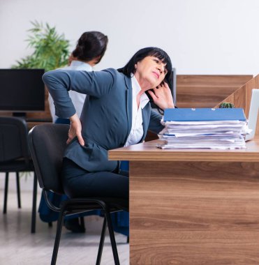 Ofiste spor egzersizleri yapan iki çalışan.