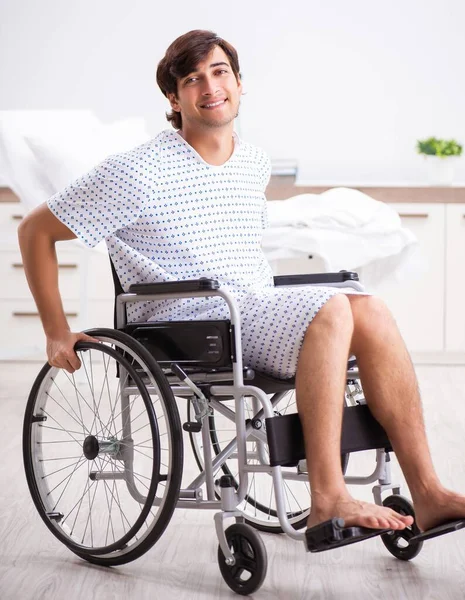 Der junge hübsche Mann im Rollstuhl im Krankenhaus — Stockfoto