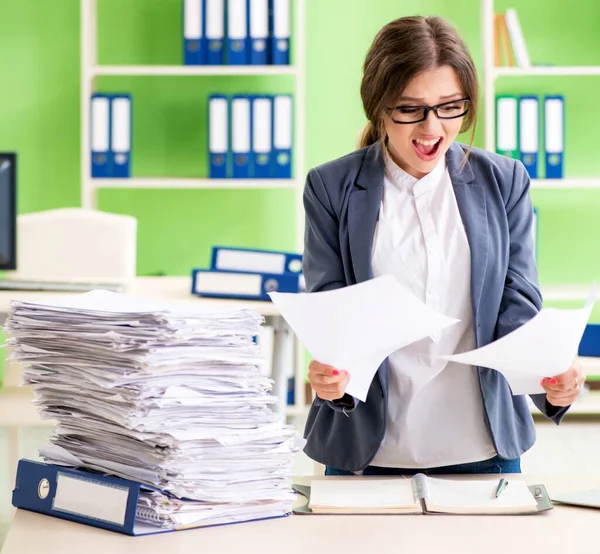 Jonge vrouwelijke werknemer zeer druk met doorlopend papierwerk — Stockfoto