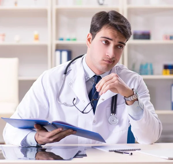 Młody lekarz siedzi w biurze — Zdjęcie stockowe