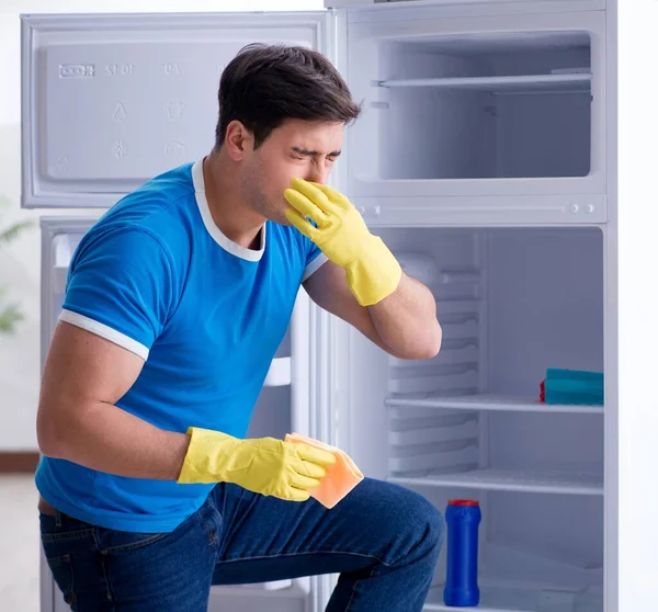 Uomo pulizia frigorifero nel concetto di igiene — Foto Stock