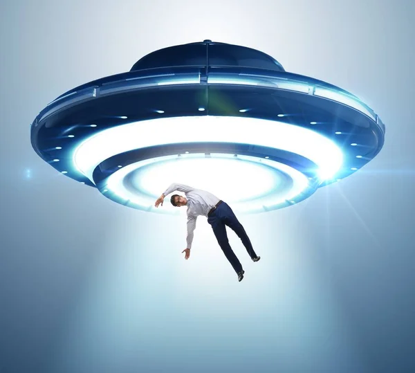 The flying saucer abducting young businessman — Stock Photo, Image