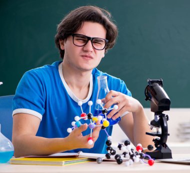 Sınıftaki genç erkek öğrenci.