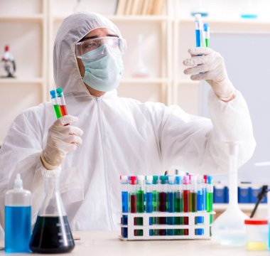 Laboratuvarda çalışan genç yakışıklı kimyager.