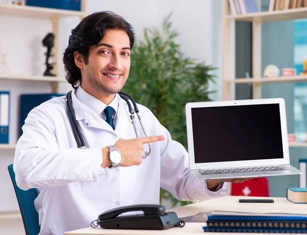 El joven guapo doctor en concepto de telemedicina — Foto de Stock
