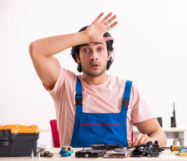 Молодой мужчина-подрядчик ремонтирует компьютер — стоковое фото