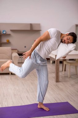 Genç adam evde spor yapıyor.