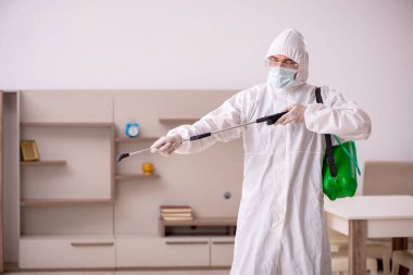 Genç erkek müteahhit evde haşere kontrolü yapıyor.