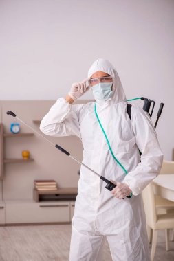 Genç erkek müteahhit evde haşere kontrolü yapıyor.