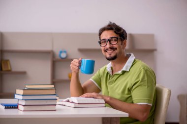 Evde okuyan genç bir erkek öğrenci.