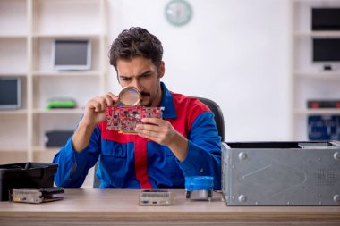 Bilgisayar tamir eden genç bir erkek tamirci.