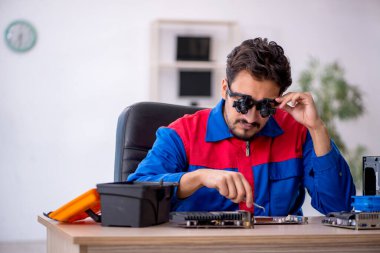 Bilgisayar tamir eden genç bir erkek tamirci.