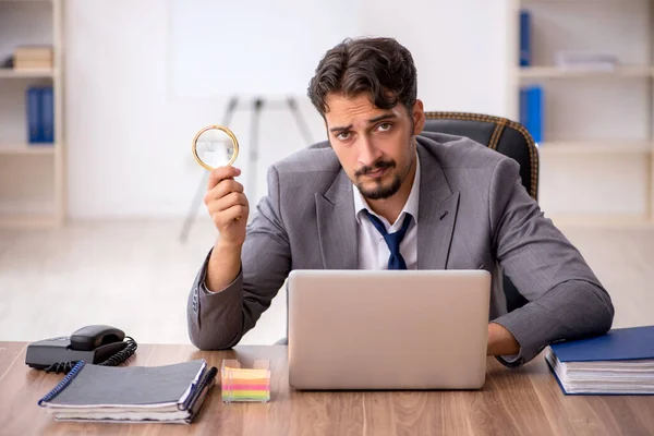 Jeune employé masculin assis dans le bureau — Photo