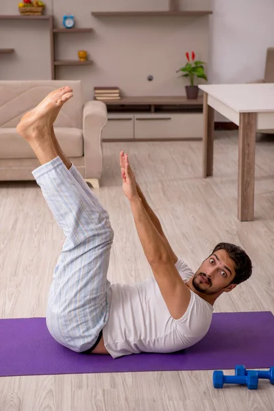 Young man doing sport exercises at home — Stock Photo, Image
