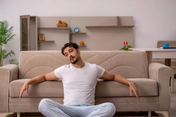 Jovem fazendo exercícios esportivos em casa — Fotografia de Stock