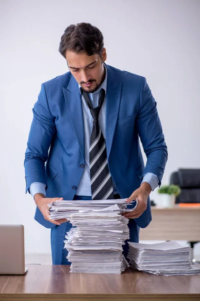 Ung manlig anställd missnöjd med överdrivet arbete på kontoret — Stockfoto