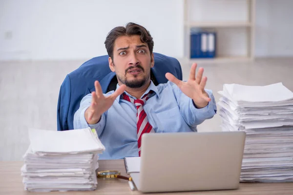 Junge männliche Mitarbeiter und zu viel Arbeit im Büro — Stockfoto