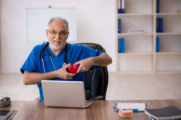 Klinikte çalışan yaşlı bir erkek kardiyolog. — Stok fotoğraf