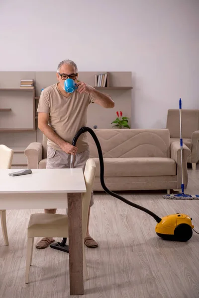 Vieil homme faisant des travaux ménagers à la maison — Photo