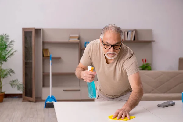 Oude man doet huishoudelijk werk thuis — Stockfoto