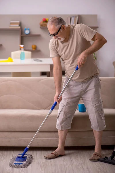 Velho fazendo tarefas domésticas em casa — Fotografia de Stock