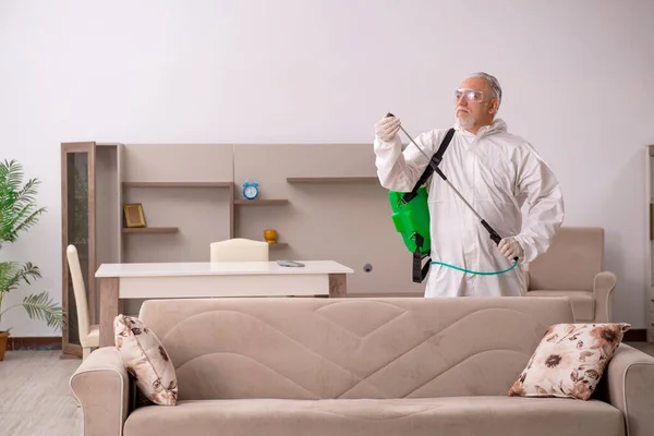 Viejo contratista masculino haciendo control de plagas en casa — Foto de Stock