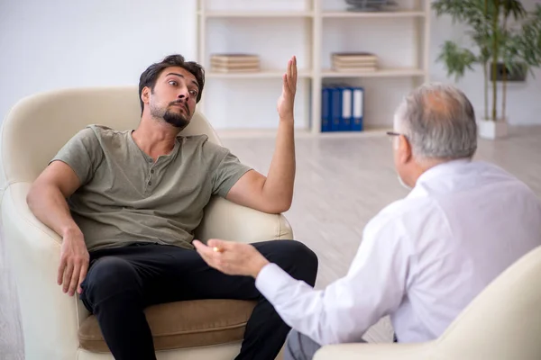 Young man visiting old psychologist — Stock Photo, Image