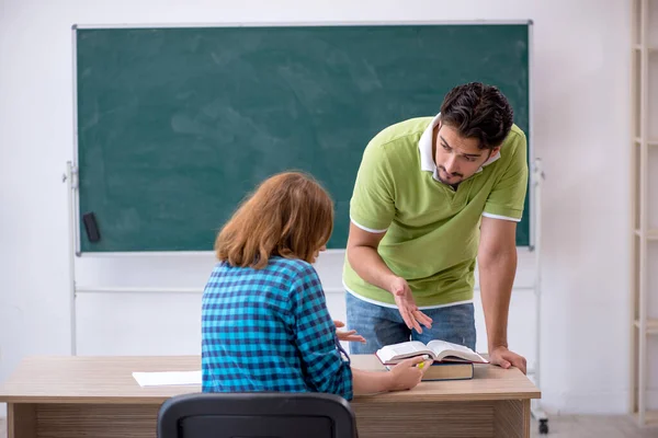 Joven profesor y estudiante en el aula — Foto de Stock