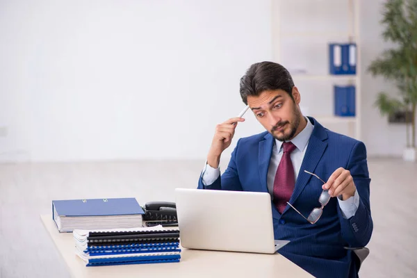 Jonge mannelijke werknemer die op de werkplek werkt — Stockfoto