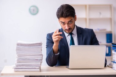 Genç işadamı ve ofiste çok fazla iş var.