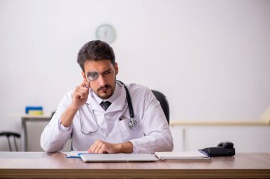 Klinikte çalışan genç erkek doktor.