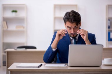 Ofiste çalışan genç bir erkek.