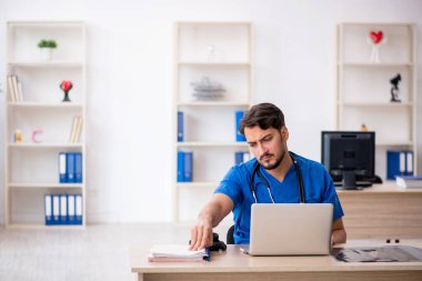 Klinikte çalışan genç erkek doktor.