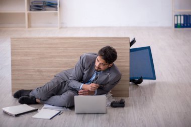 Genç erkek çalışan ofiste fazla mesai yapıyor.