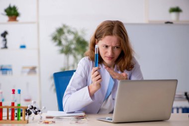 Laboratuarda çalışan genç bir kadın kimyager.